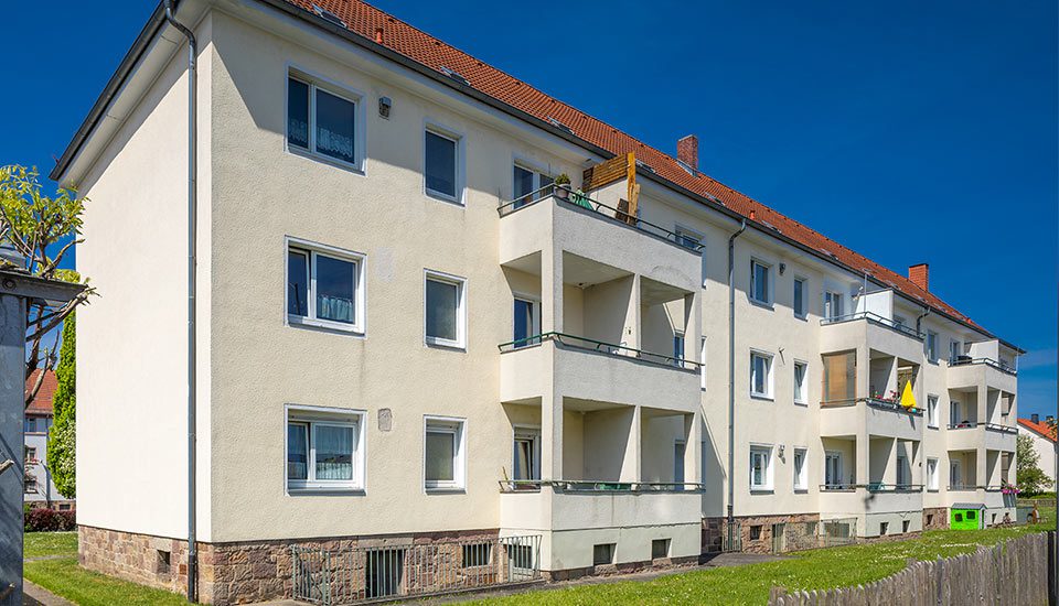 Das Foto zeigt ein Mehrfamilienhaus in Fulda. Es ist von einer Grünfläche umgeben und besitzt mehrere getrennte Balkons.